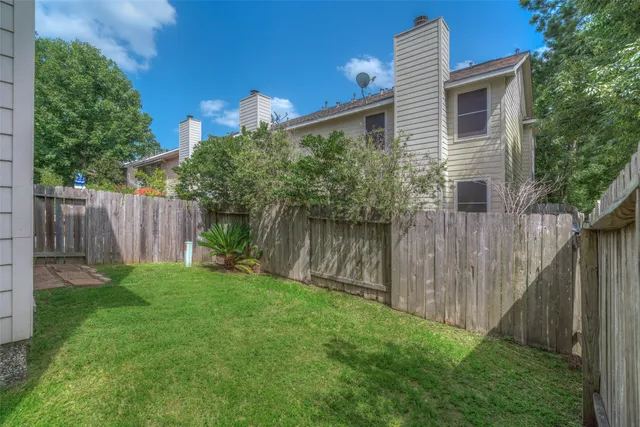 a view of a backyard with plants and wooden fence