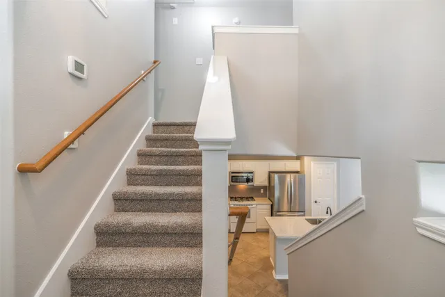 a view of staircase with white walls and a table