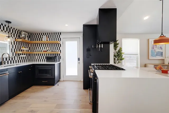 a kitchen with a sink and a stove top oven