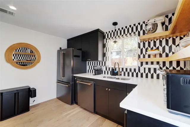 a kitchen with granite countertop a sink a stove and a refrigerator
