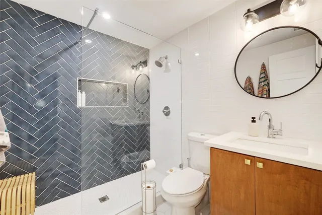 a bathroom with a sink a toilet and a mirror