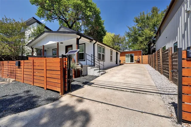a view of a white house with wooden fence
