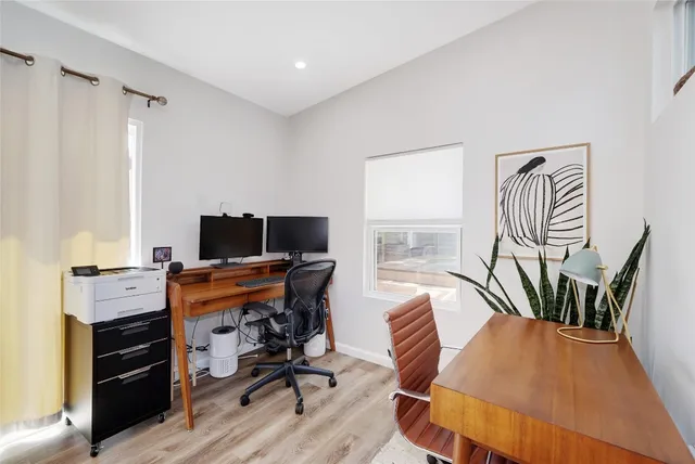a view of a workspace with furniture and a window