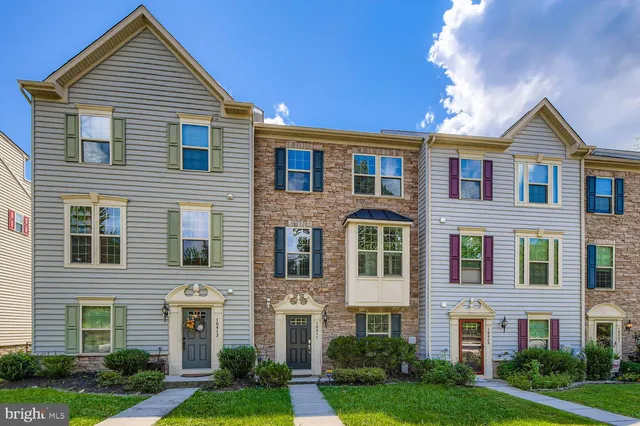 a front view of a house with yard and green space