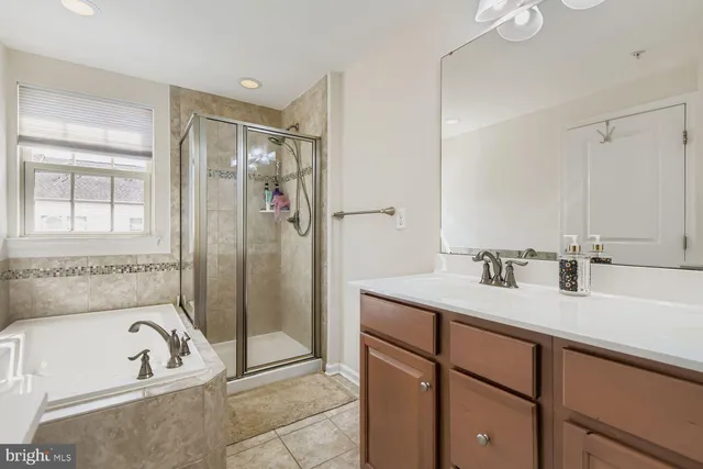 a bathroom with a tub sink and mirror