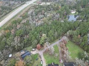 a yard with a house and trees all around