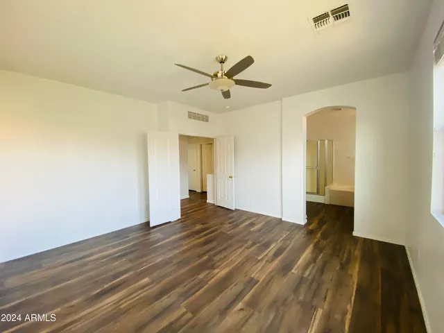 a view of a livingroom with wooden floor and a ceiling fan