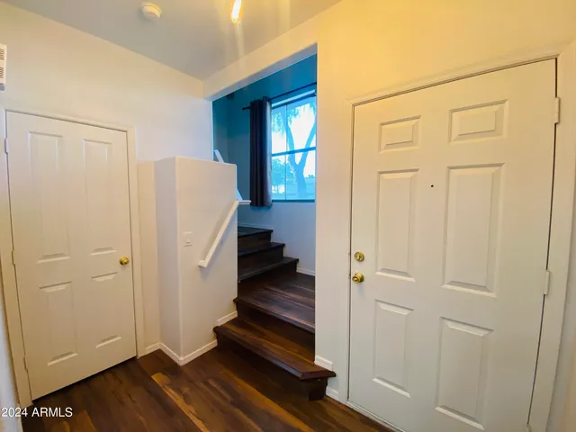 a view of a hallway with wooden floor and entryway