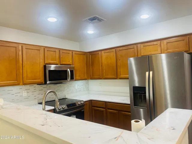 a kitchen with granite countertop a refrigerator and a sink