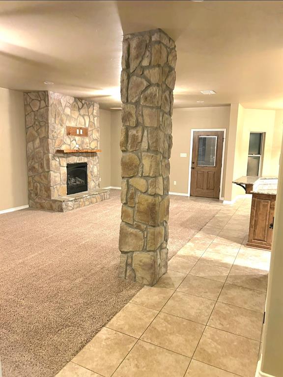 1118 Elk Ridge Drive Stephenville, TX 76401 - Photo 20 of 40 a living room with furniture a fireplace and a flat screen tv
