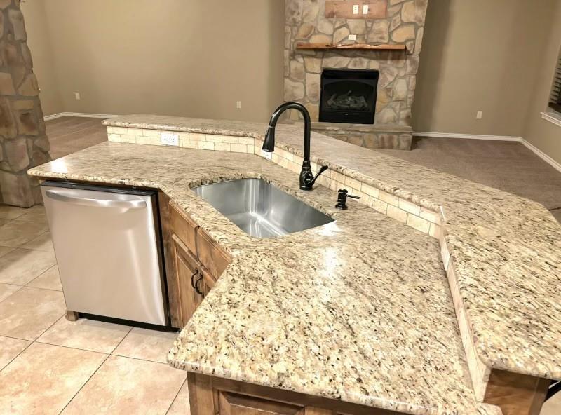 1118 Elk Ridge Drive Stephenville, TX 76401 - Photo 30 of 40 a kitchen with granite countertop a sink and a stove