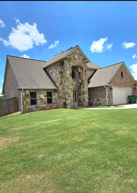 1118 Elk Ridge Drive Stephenville, TX 76401 - Photo 3 of 40 a front view of a house with a yard