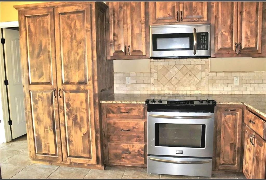 1118 Elk Ridge Drive Stephenville, TX 76401 - Photo 39 of 40 a stove top oven sitting inside of a kitchen