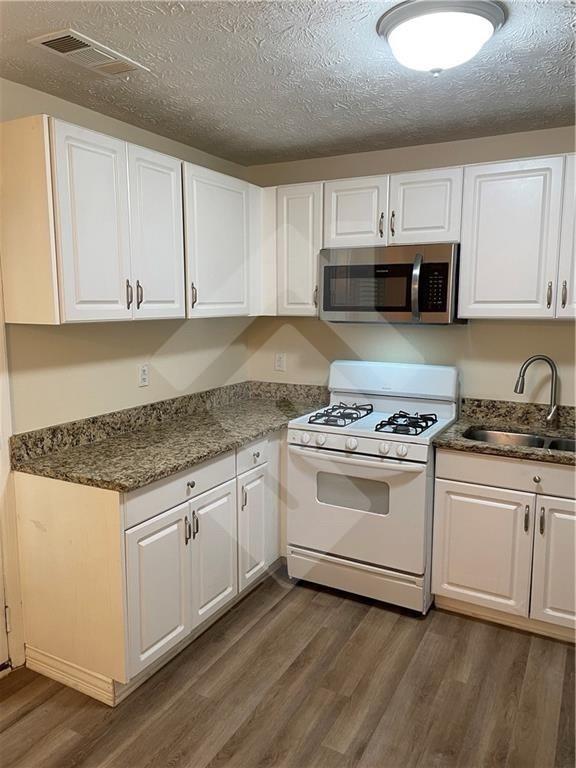 4267 Grogan Street Acworth, GA 30101 - Photo 10 of 37 a kitchen with granite countertop white cabinets and white appliances