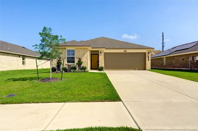 a front view of a house with a yard and potted plants