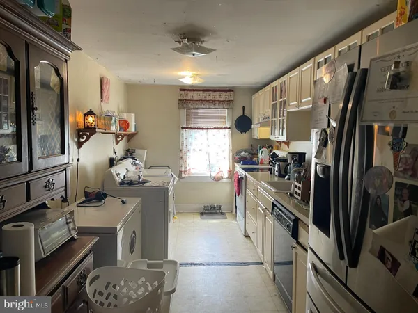 a kitchen with refrigerator and wooden floor