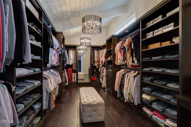 a view of walk in closet with clothes and shoes