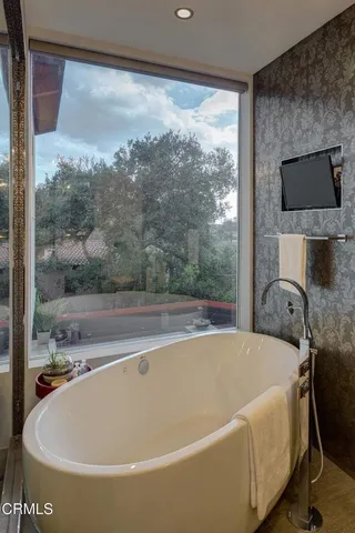 a white bath tub sitting in a bathroom next to a window