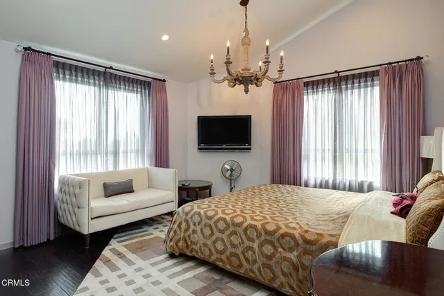 a bedroom with a large bed a flat screen tv and a couch