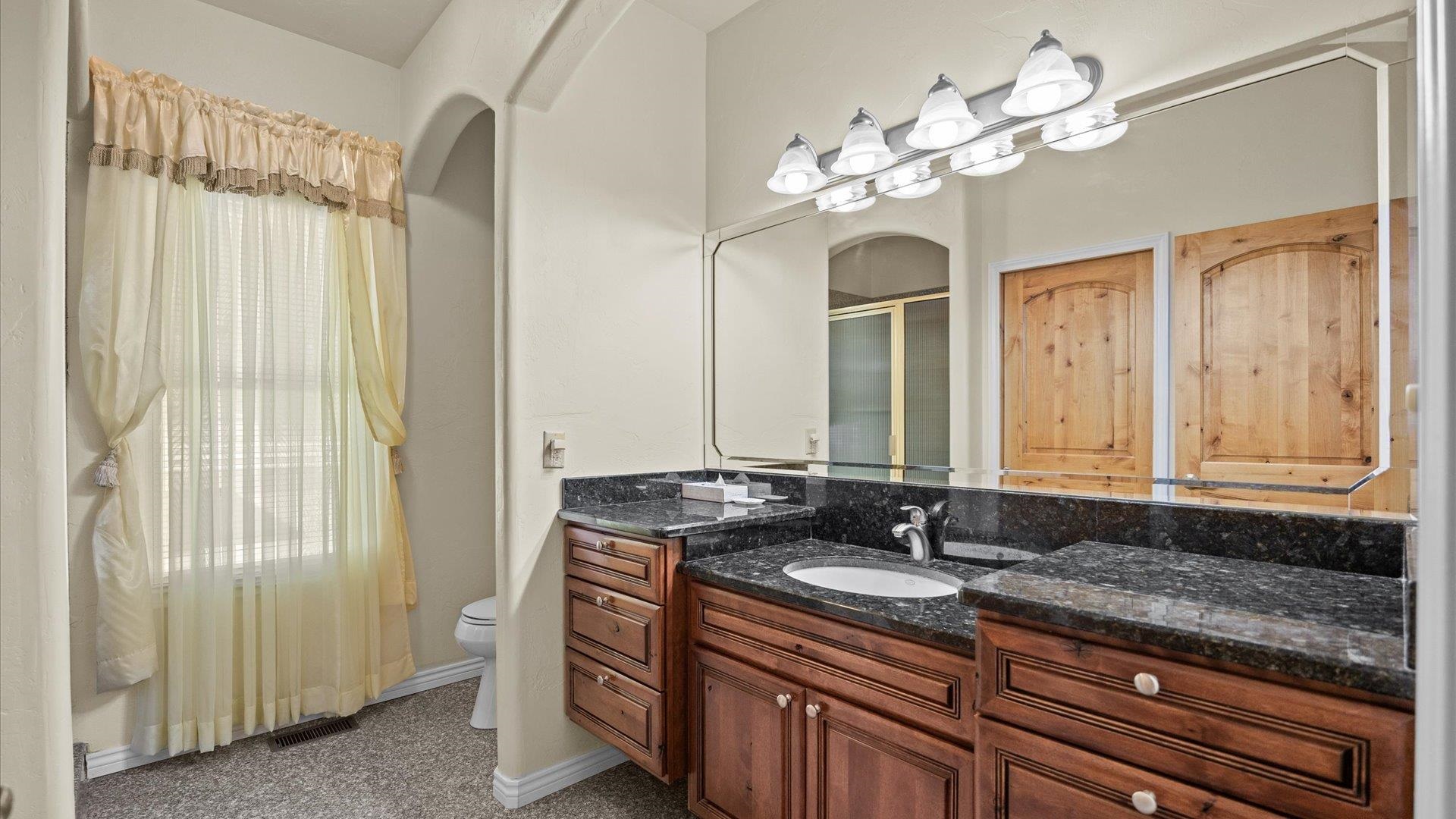 4590 Old Kannah Creek Road Whitewater, CO 81527 - Photo 26 of 35 a bathroom with a granite countertop sink a large mirror and a shower