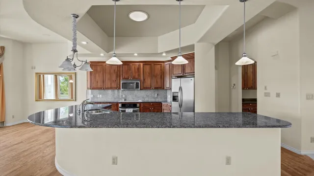 a kitchen with granite countertop a stove and refrigerator