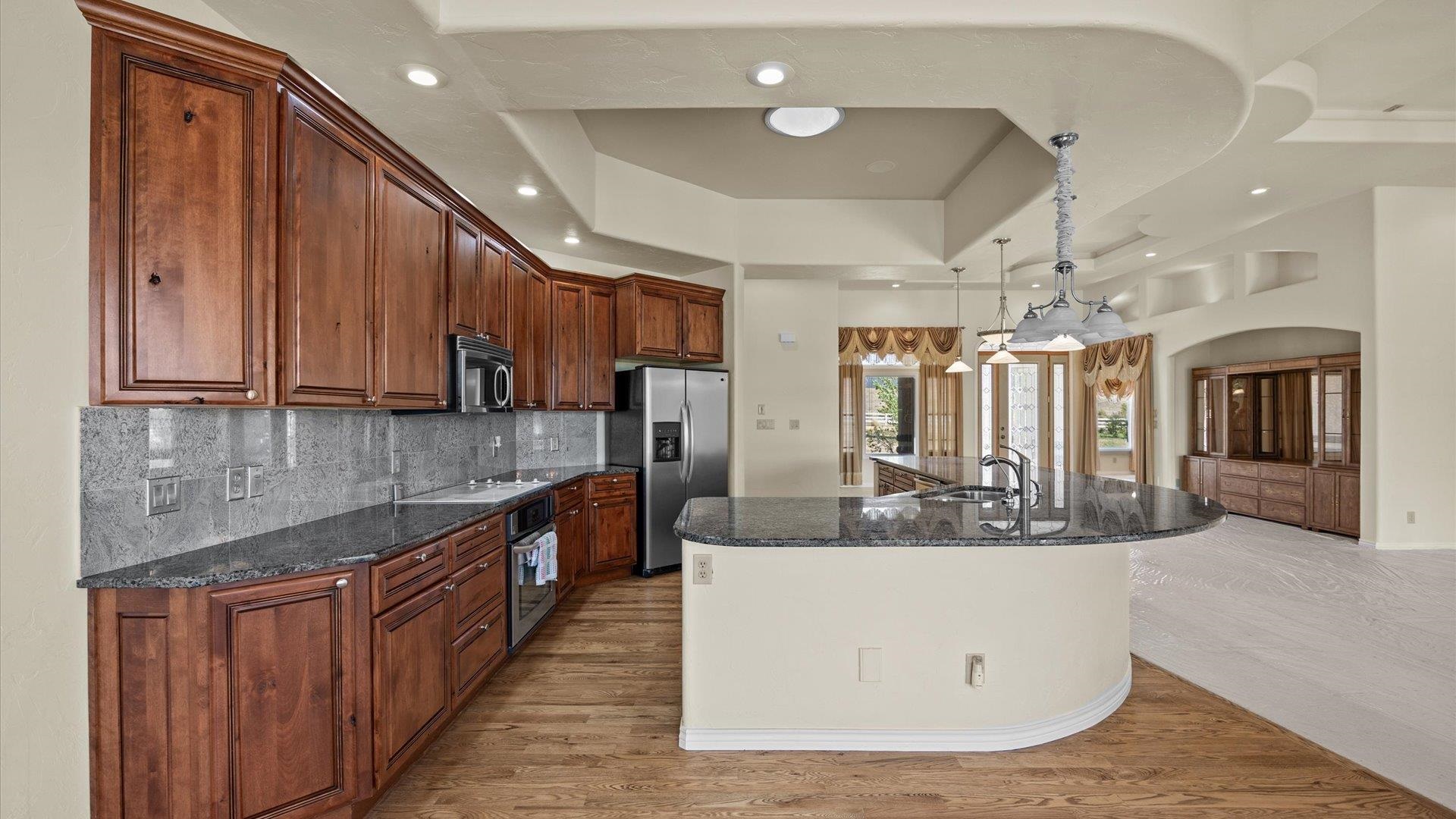 4590 Old Kannah Creek Road Whitewater, CO 81527 - Photo 8 of 35 a large kitchen with kitchen island granite countertop wooden cabinets and a granite counter tops