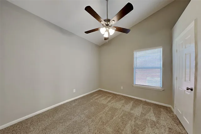 an empty room with window and ceiling fan