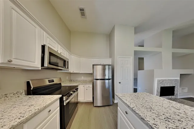 a kitchen with stainless steel appliances granite countertop a refrigerator stove microwave and sink