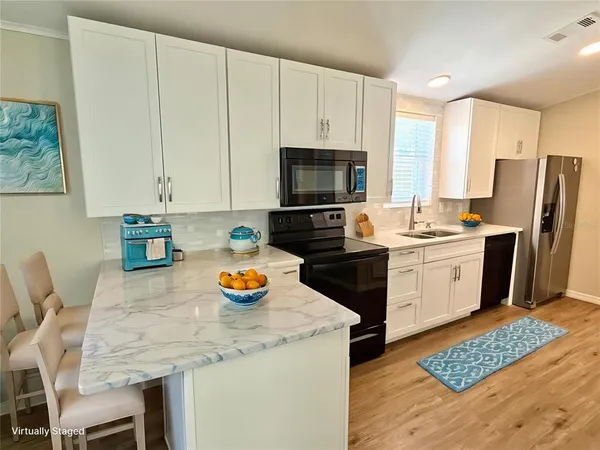 a kitchen with a sink a stove and chairs