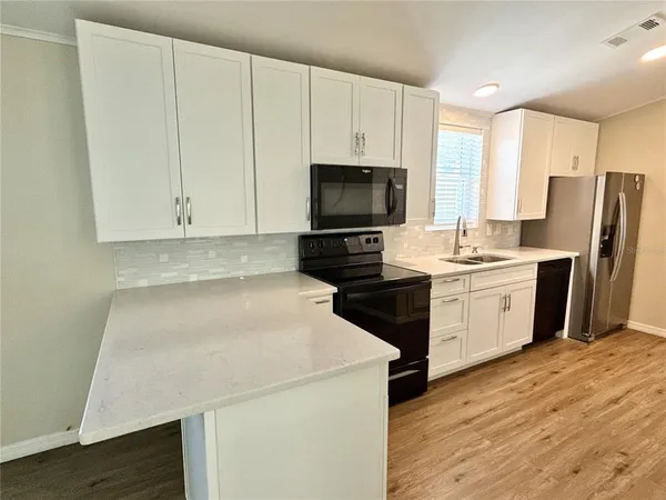 a kitchen with a sink a microwave a stove and refrigerator
