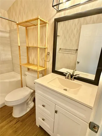 a bathroom with a sink mirror vanity and toilet