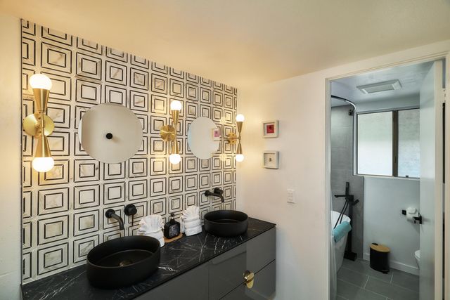 a bathroom with a sink a mirror and a shower