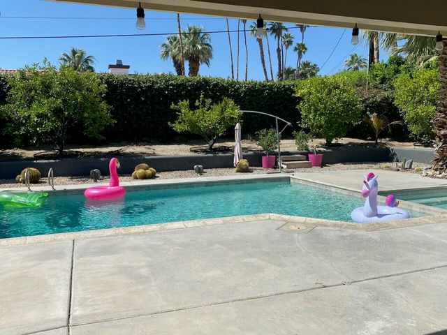 a view of yard with swimming pool and green space