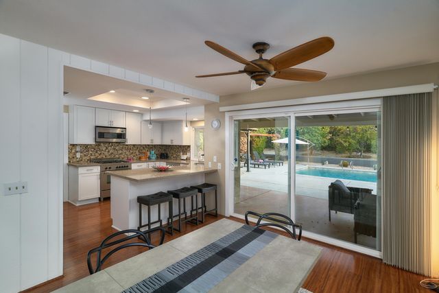 a open kitchen with stainless steel appliances granite countertop a refrigerator and a stove top oven
