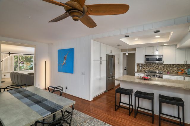 a kitchen with a table chairs refrigerator and cabinets