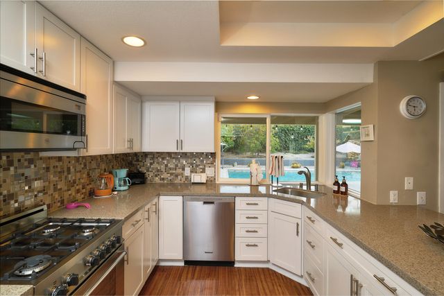 a kitchen with a sink stove top oven and cabinets
