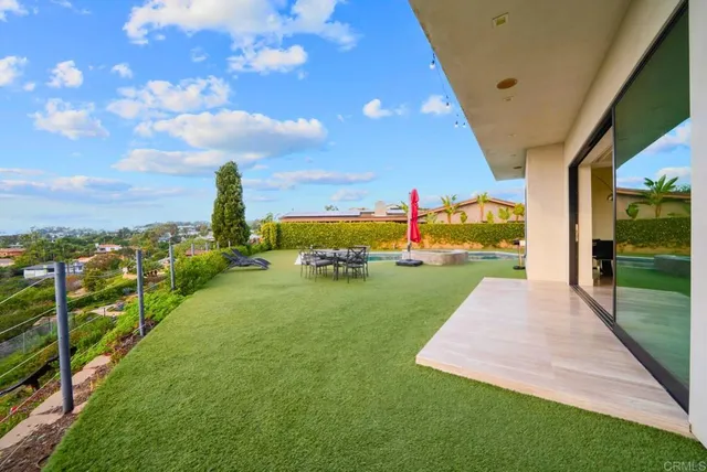 a view of a swimming pool with lawn chairs under an umbrella