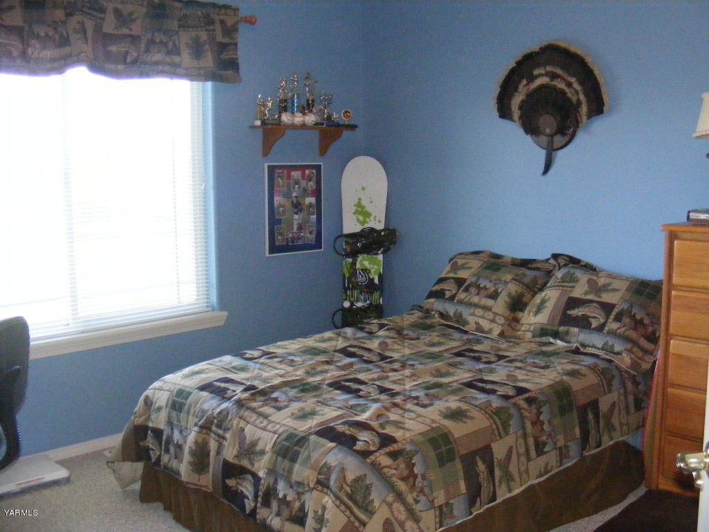 15012 Fisk Road Yakima, WA 98908 - Photo 13 of 23 a bed sitting in a bedroom next to a window