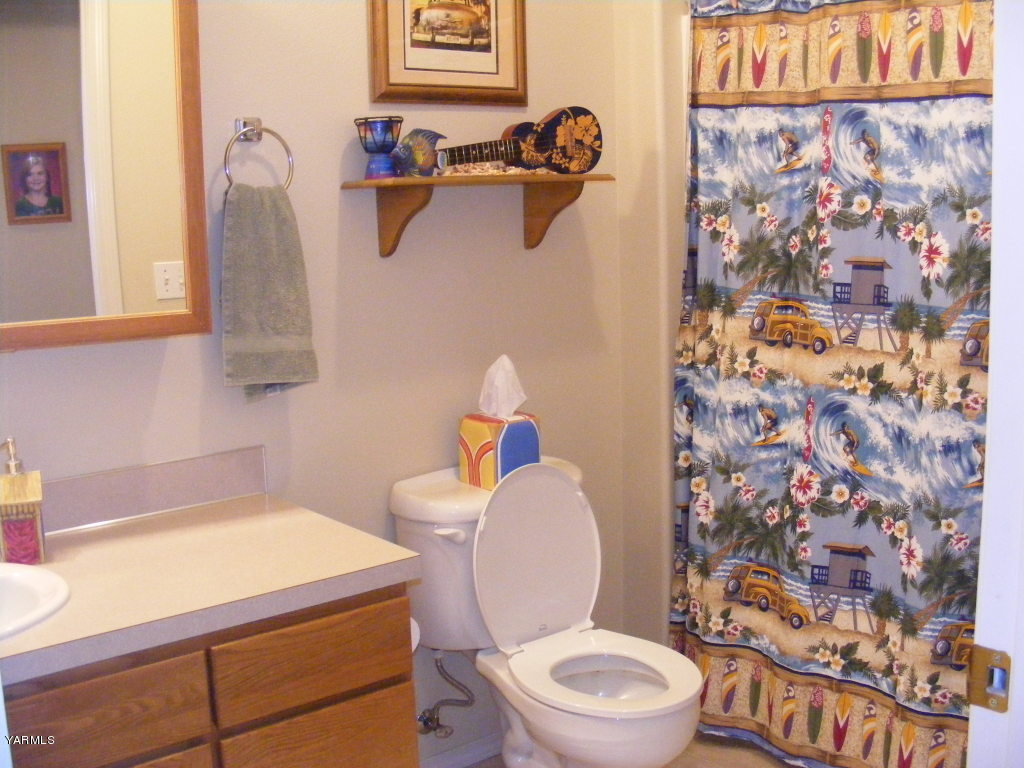 15012 Fisk Road Yakima, WA 98908 - Photo 19 of 23 a bathroom with a toilet a sink and a shower curtain