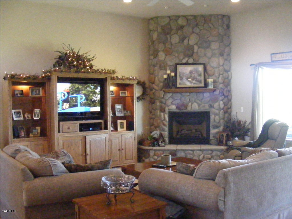 15012 Fisk Road Yakima, WA 98908 - Photo 3 of 23 a living room with furniture a flat screen tv and a fireplace