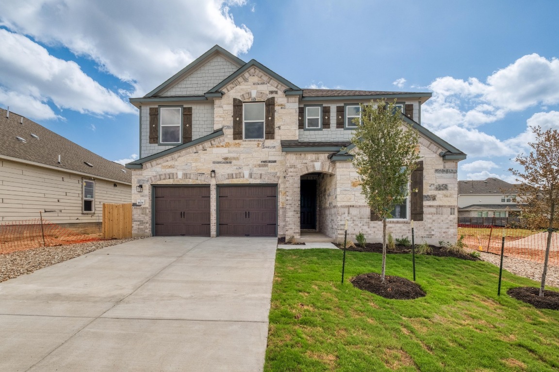 a front view of house with a garden and trees
