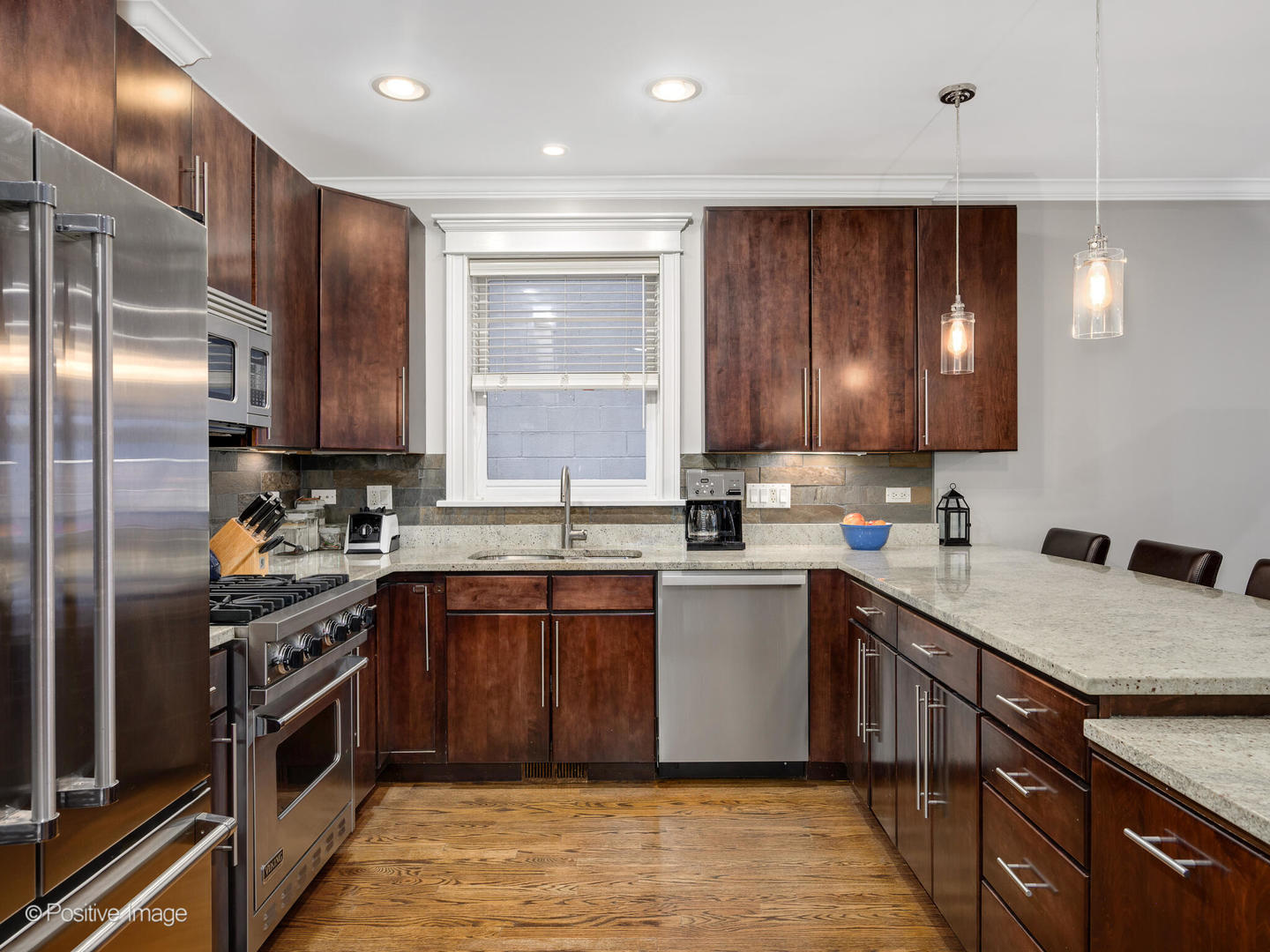 1745 West Roscoe Street, Unit 1 Chicago, IL 60657 - Photo 9 of 29 a kitchen with stainless steel appliances granite countertop wooden cabinets a sink and a stove
