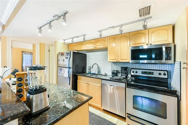 a kitchen with stainless steel appliances kitchen island granite countertop a stove and cabinets