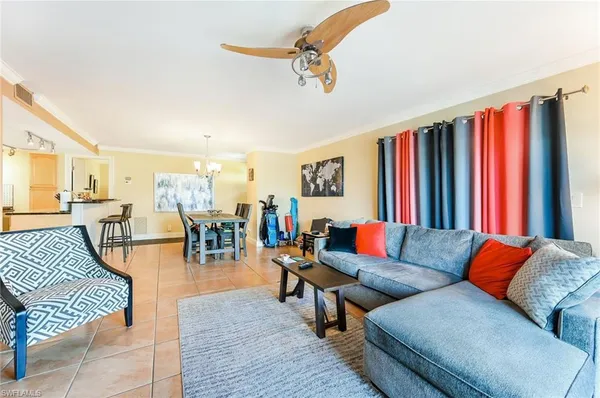 a living room with furniture kitchen view and a large window