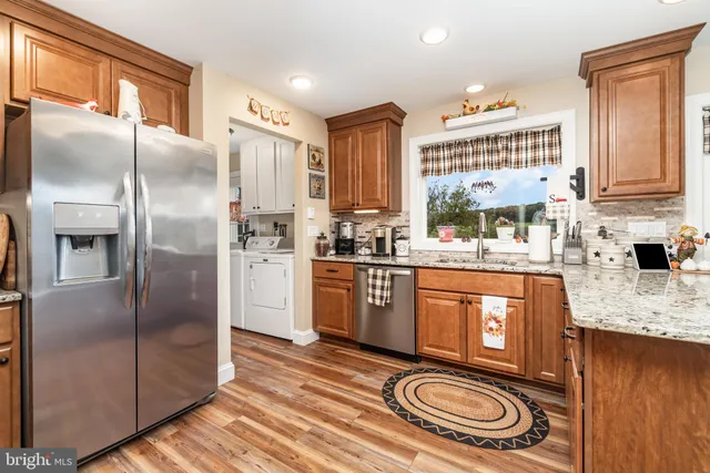 a kitchen with stainless steel appliances granite countertop a refrigerator a sink a stove and island