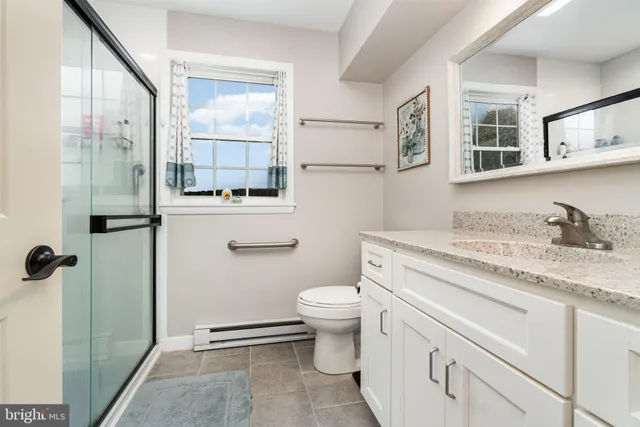a bathroom with a granite countertop sink toilet and shower