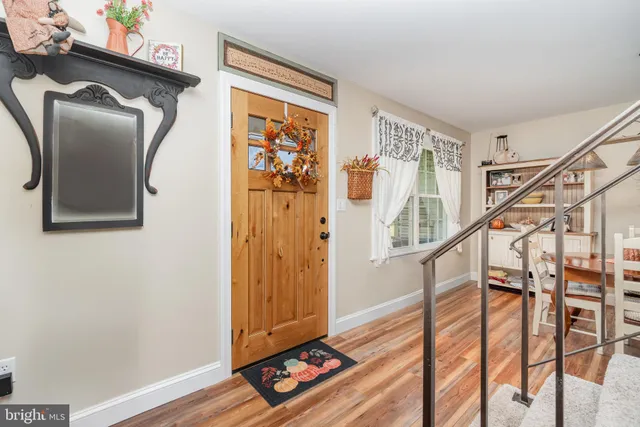 a view of front door with wooden floor and stairs