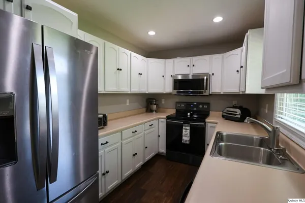 a kitchen with white cabinets and stainless steel appliances