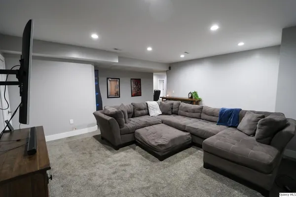 a living room with furniture a rug and a flat screen tv