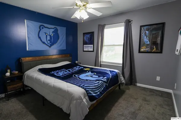 a bedroom with a large bed and a chandelier